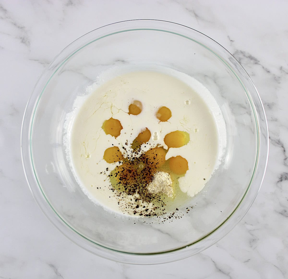 10 eggs, heavy cream, salt and pepper in glass bowl unmixed