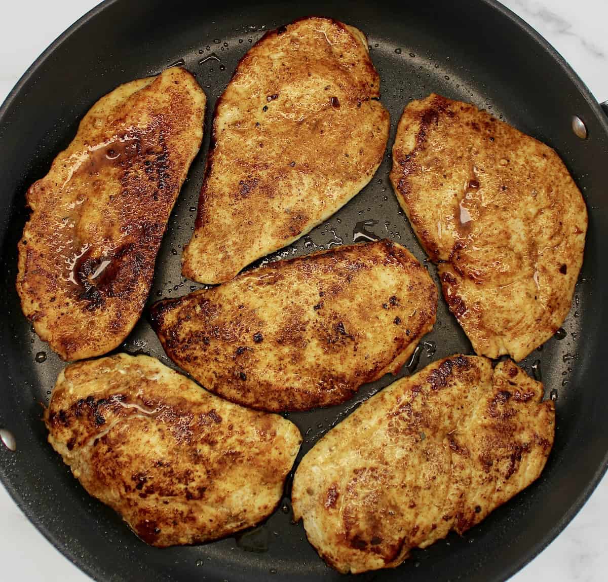 6 cooked chicken breasts with taco seasoning in skillet