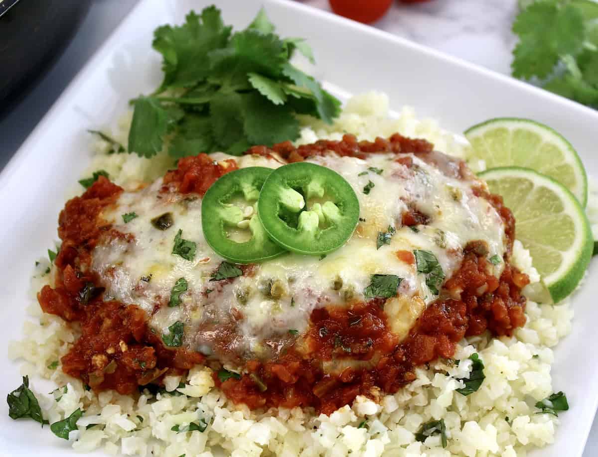 Skillet Salsa Chicken on white plate over lime cilantro cauliflower rice 