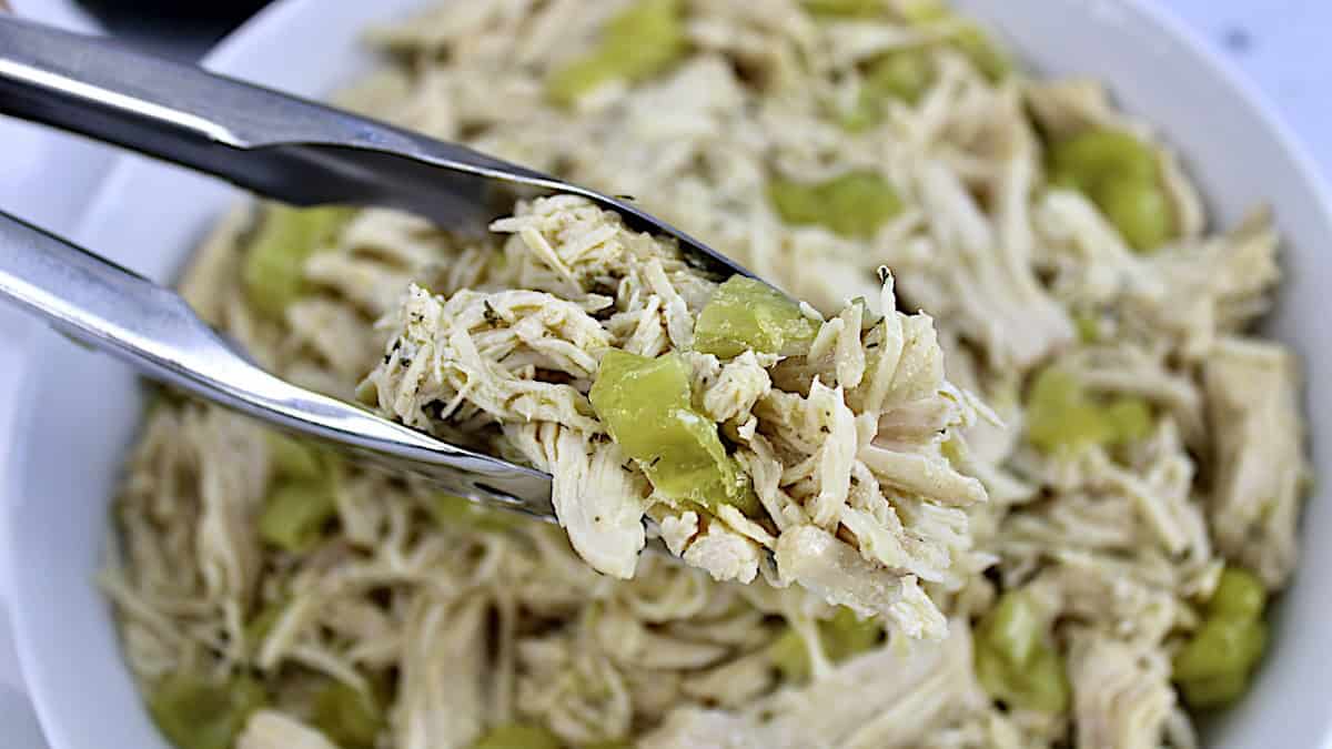 closeup of Slow Cooker Mississippi Chicken in tongs