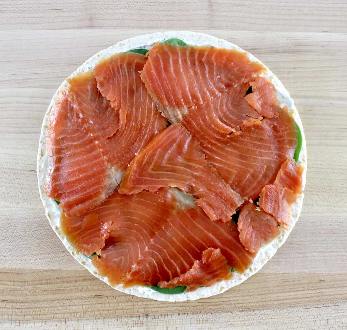 smoked salmon over tortilla on cutting board