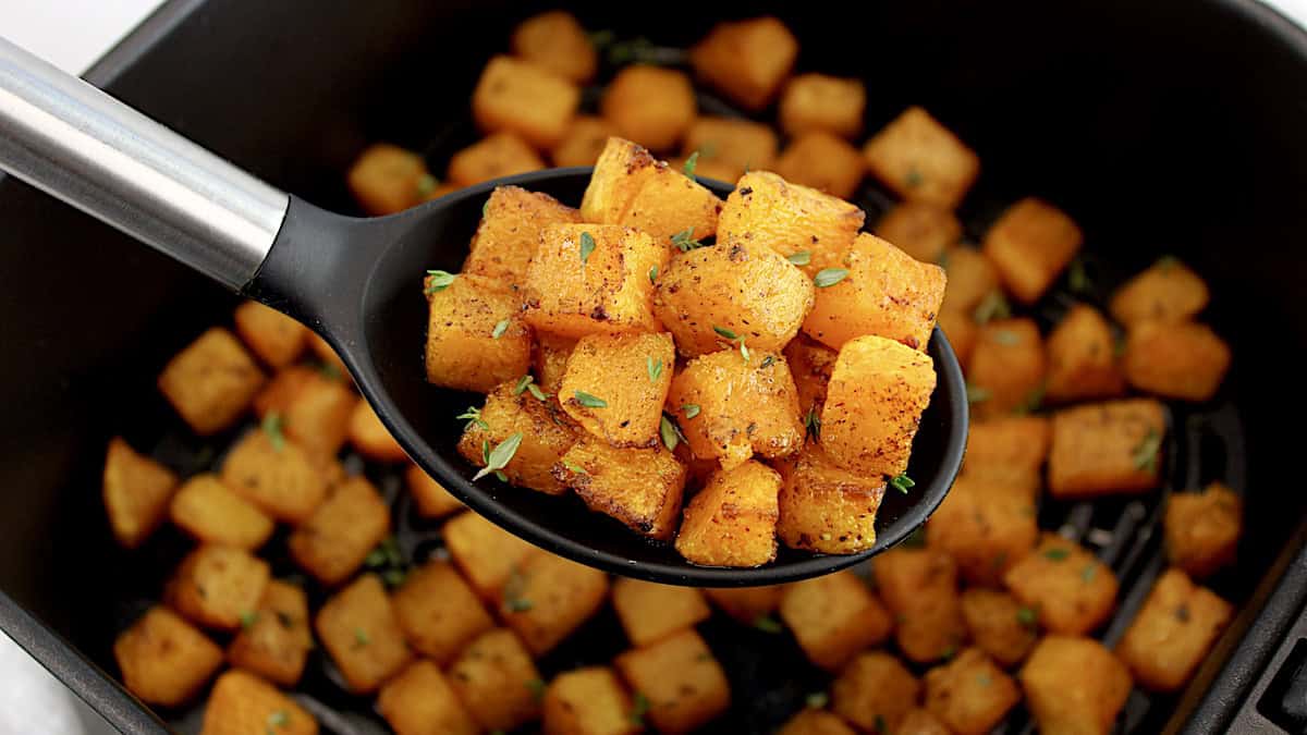 Air Fryer Butternut Squash being held up with black spoon