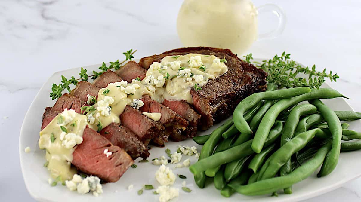 Blue Cheese Sauce over Steak with green beans on side