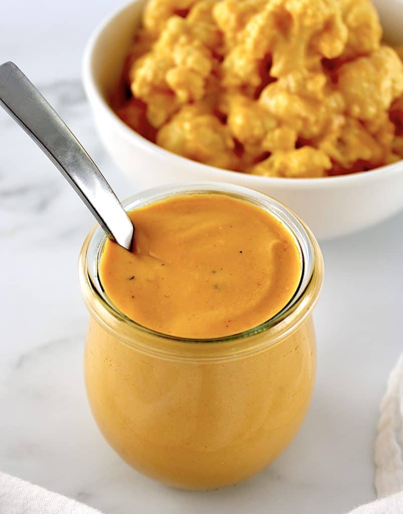 Buffalo Cheese Sauce and Dip in open glass jar with spoon sticking out