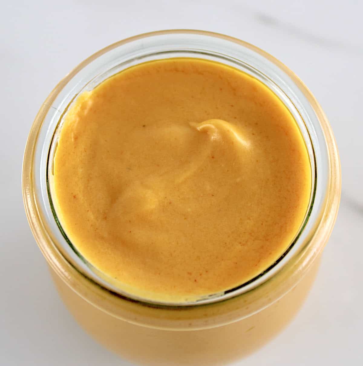 overhead view of Buffalo Cheese Sauce and Dip in open glass jar