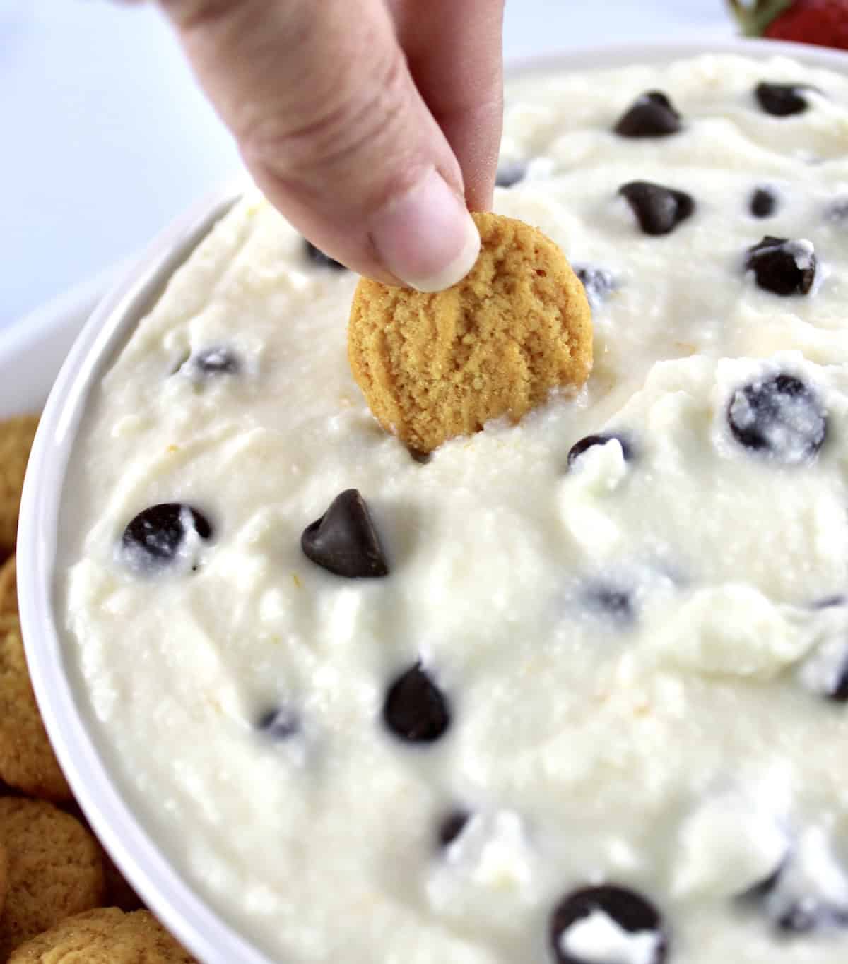 Cannoli Dip with vanilla wafer being dipped in