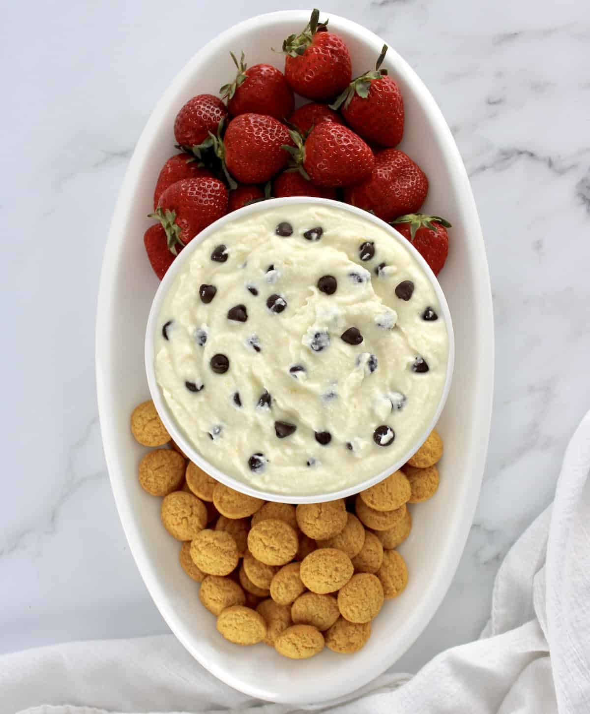 overhead view of Cannoli Dip with vanilla wafers and strawberries on side