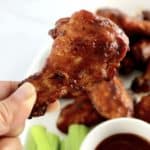 closeup of hand holding up Honey BBQ Chicken Wing