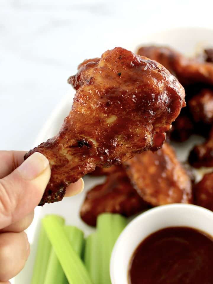 closeup of hand holding up Honey BBQ Chicken Wing