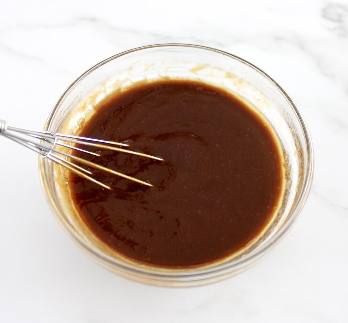 Honey BBQ Chicken Wing sauce in glass bowl with whisk