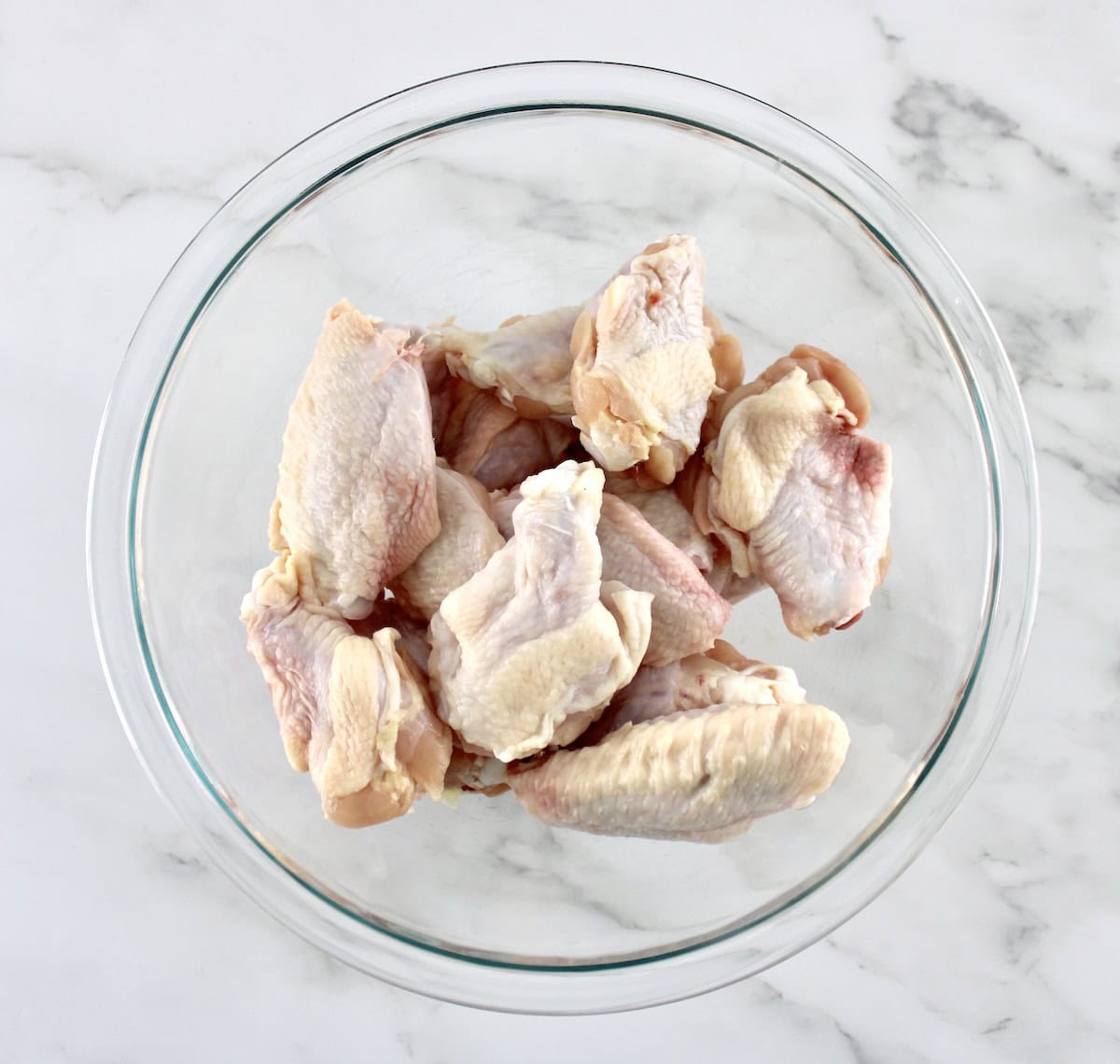 raw chicken wings in glass bowl