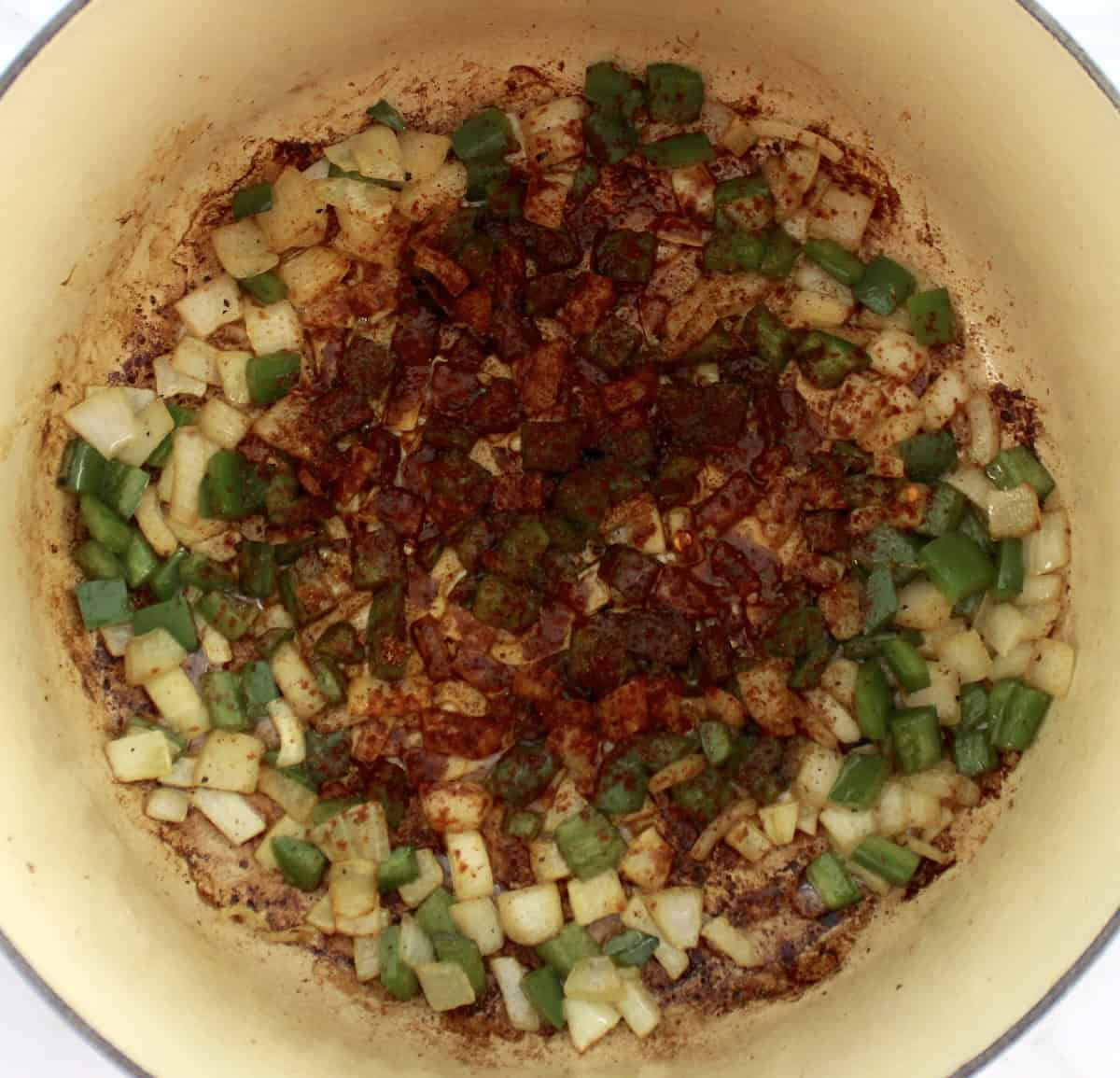 diced onions and jalapeno peppers in pot with chili seasoning