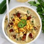 overhead view of Jalapeño Popper Chicken Soup in white bowl with spoon