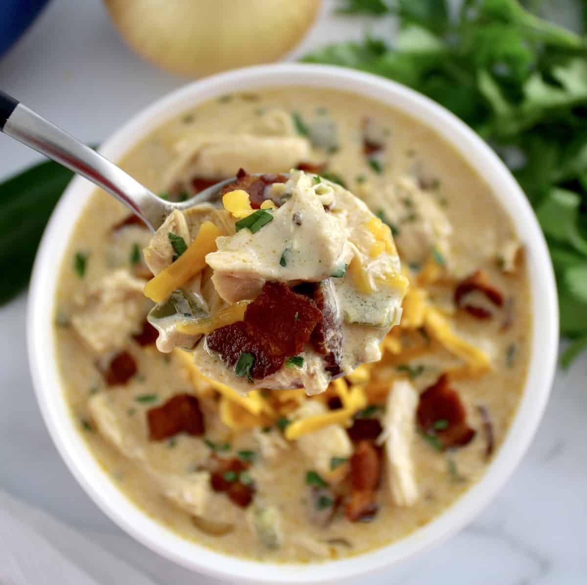 Jalapeño Popper Chicken Soup with spoonful held up over soup bowl