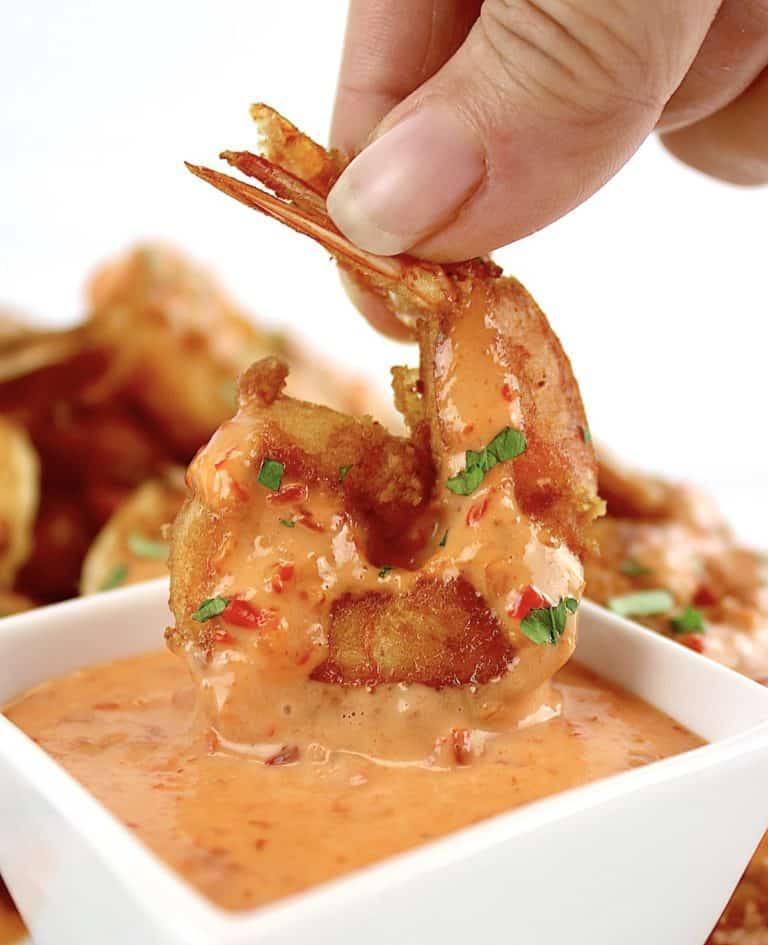 Bang Bang Shrimp being dipped in bang bang sauce