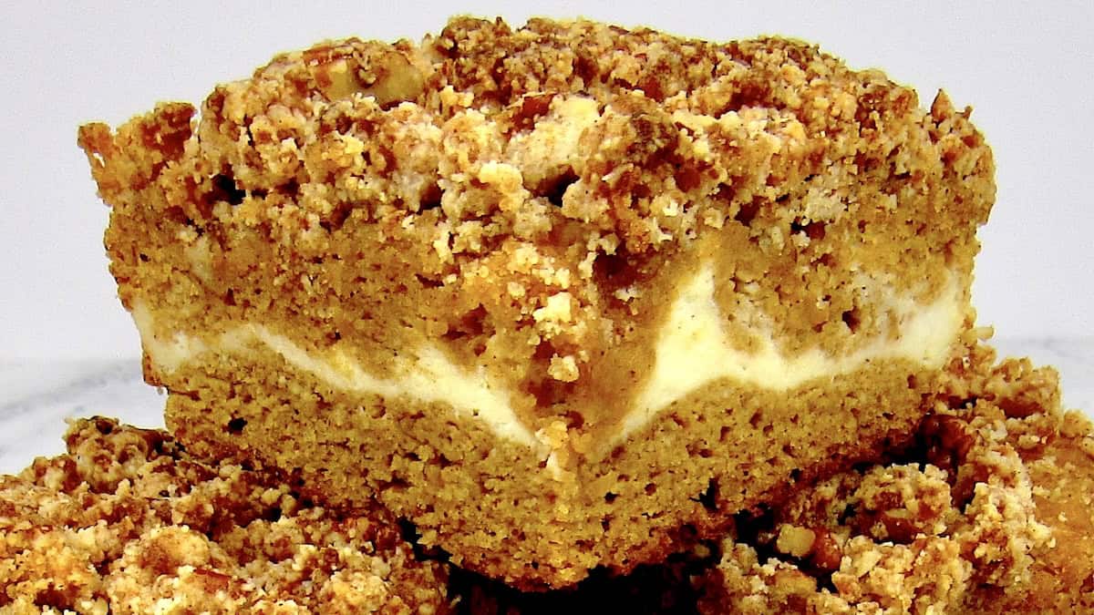 slices of pumpkin coffee cake stacked up on a square plate