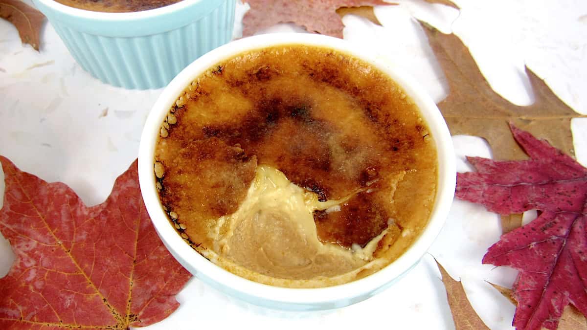 pumpkin creme Brûlée in a ramekin with fall leaves on side