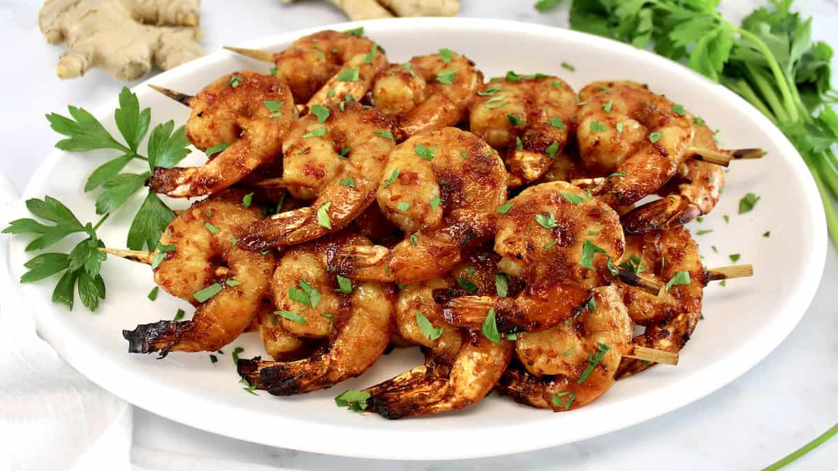 Air Fryer Asian Shrimp Skewers on white oval platter with chopped parsley