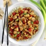 overhead view of Cashew Chicken over cauliflower rice with black chopsticks on side