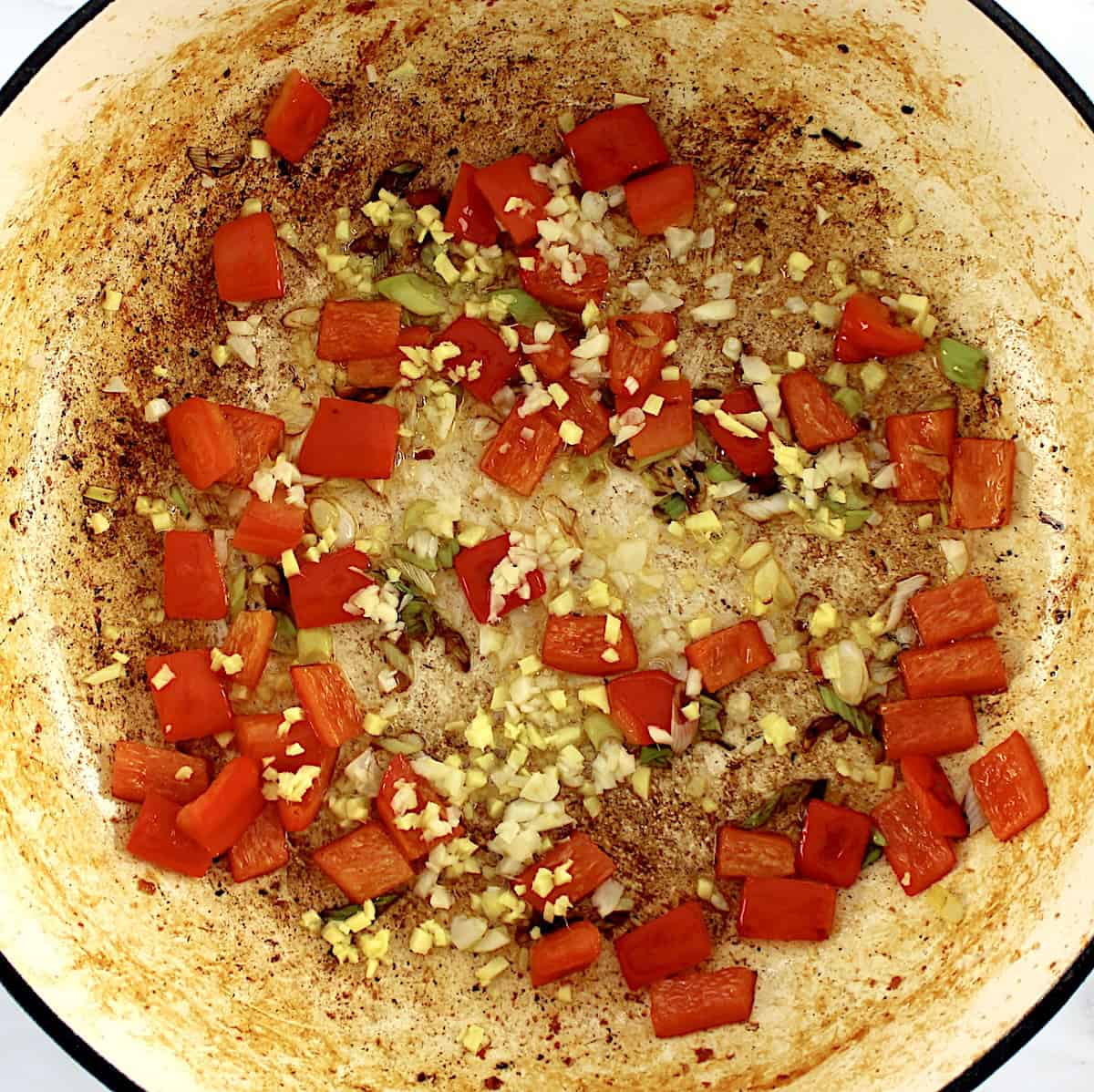 red bell pepper, scallions, ginger and garlic in skillet