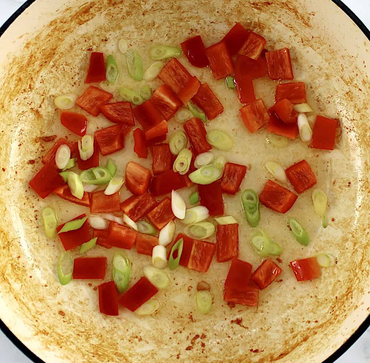 red bell pepper and scallions in skillet