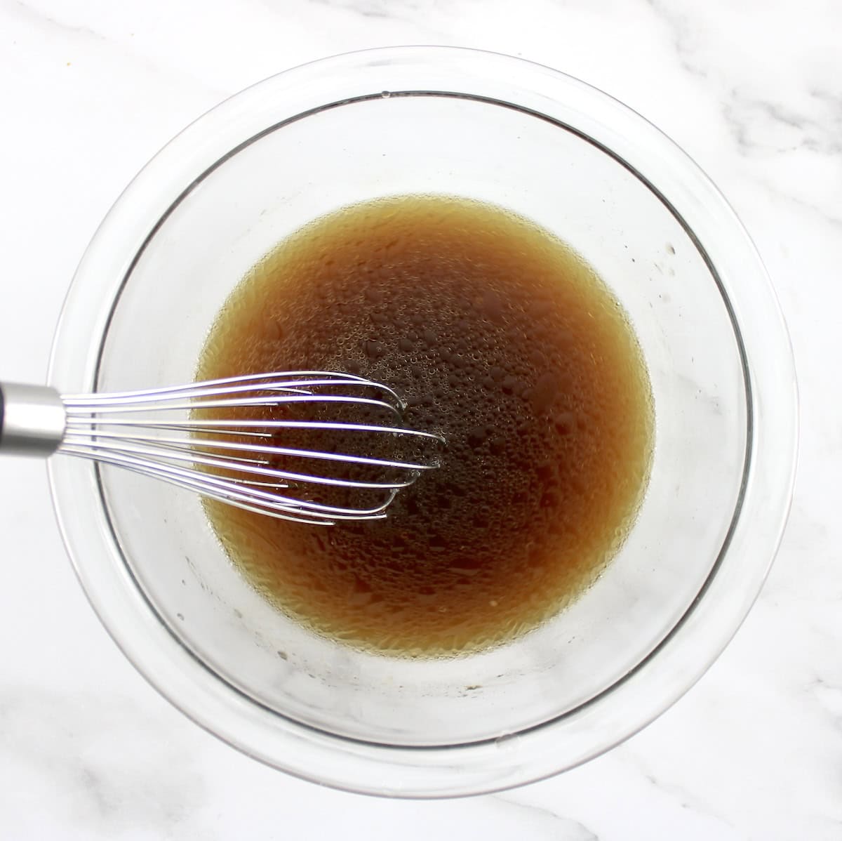 Cashew Chicken sauce in glass bowl with whisk