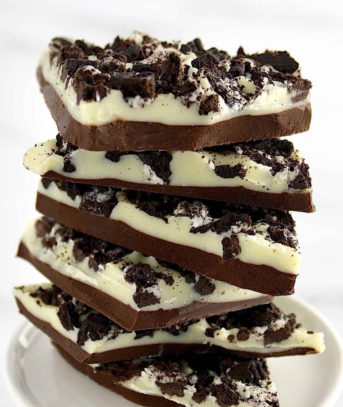 Cookies and Cream Bark pieces stacked up on white plate