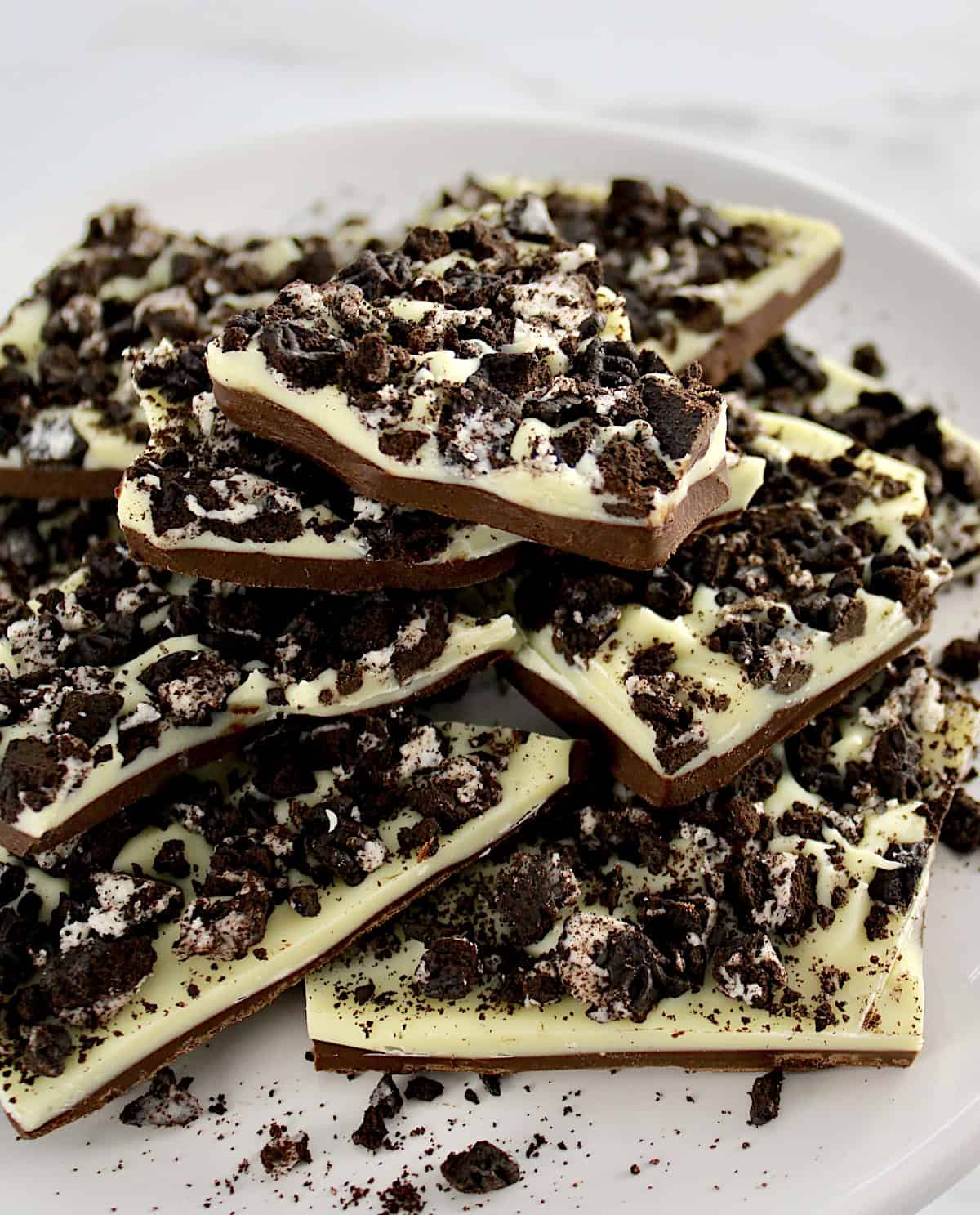 Cookies and Cream Bark pieces stacked up on white plate