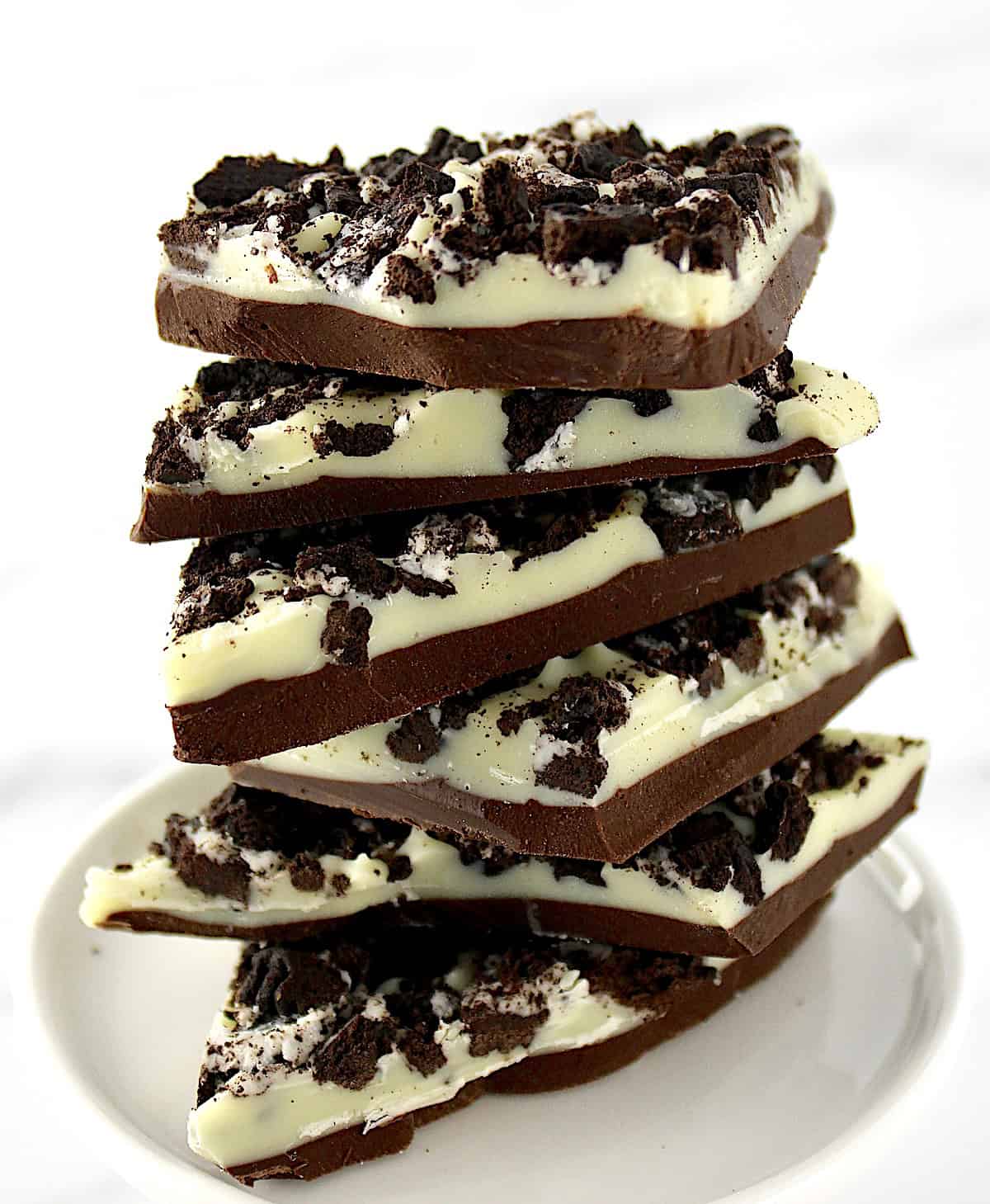 Cookies and Cream Bark pieces stacked up on white plate