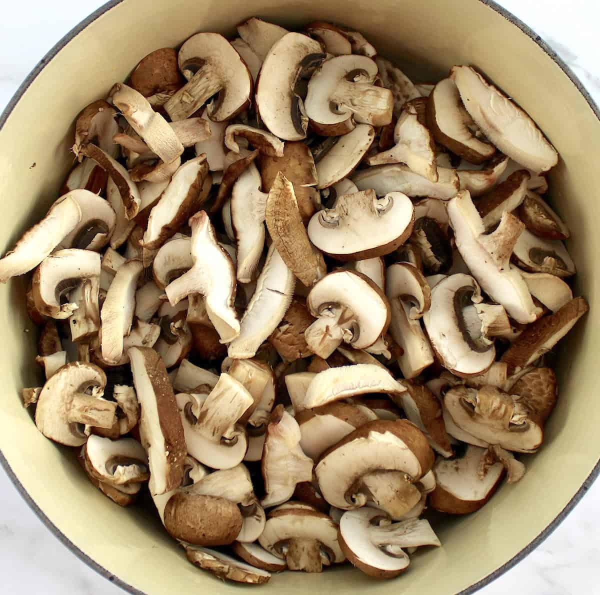 dutch oven with sliced baby bella and shiitake mushrooms