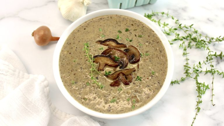 Cream of Wild Mushroom Soup in white bowl with sauteed mushrooms on top