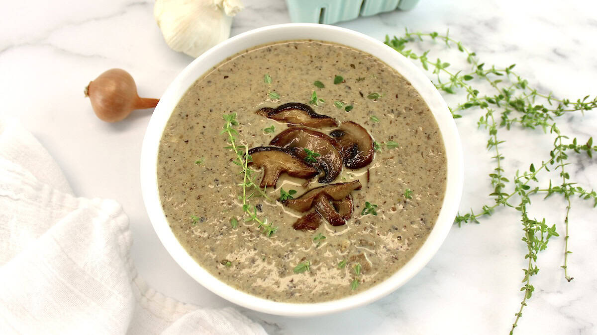 Cream of Wild Mushroom Soup in white bowl with sauteed mushrooms on top