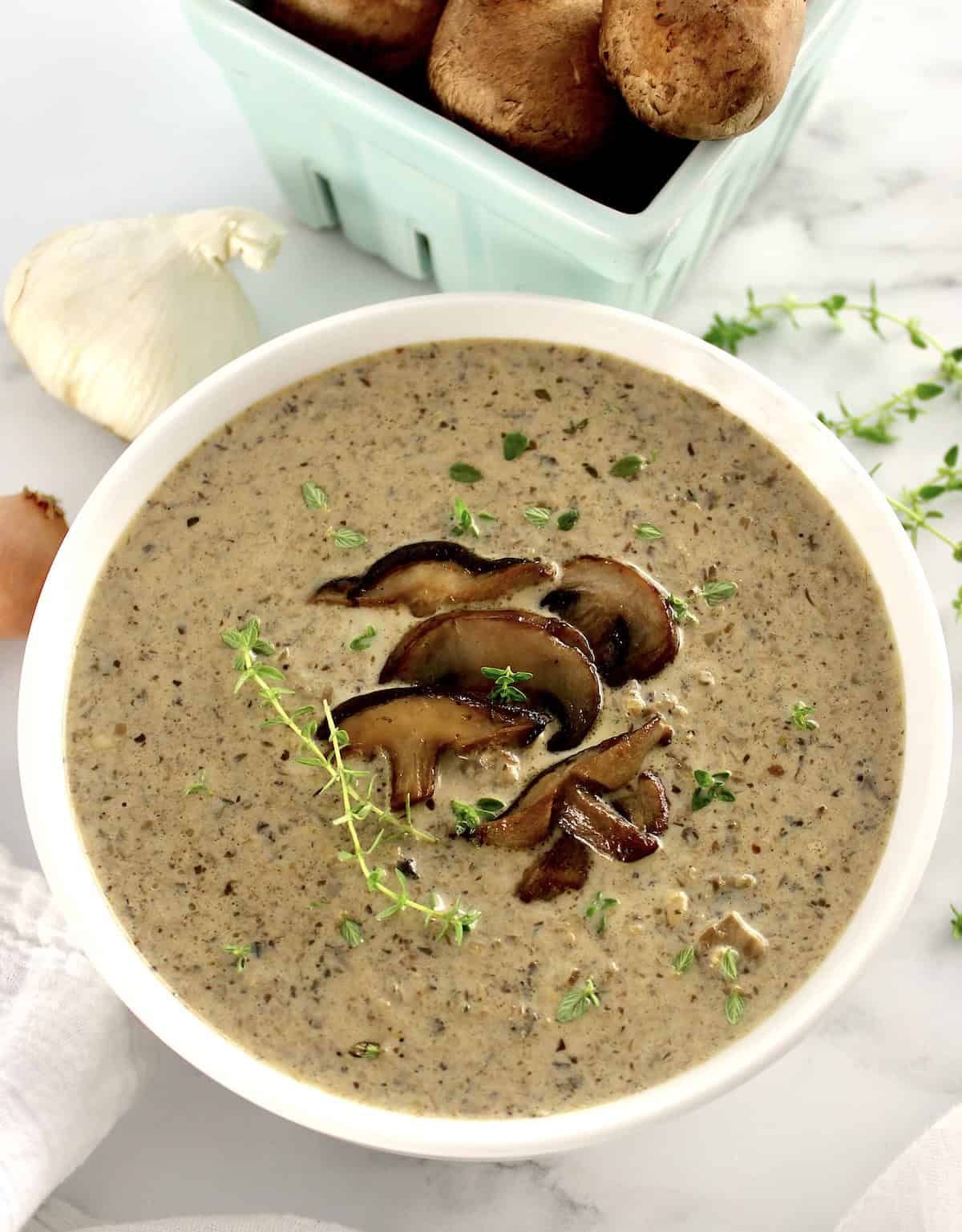 Cream of Wild Mushroom Soup in white bowl with sauteed mushrooms on top