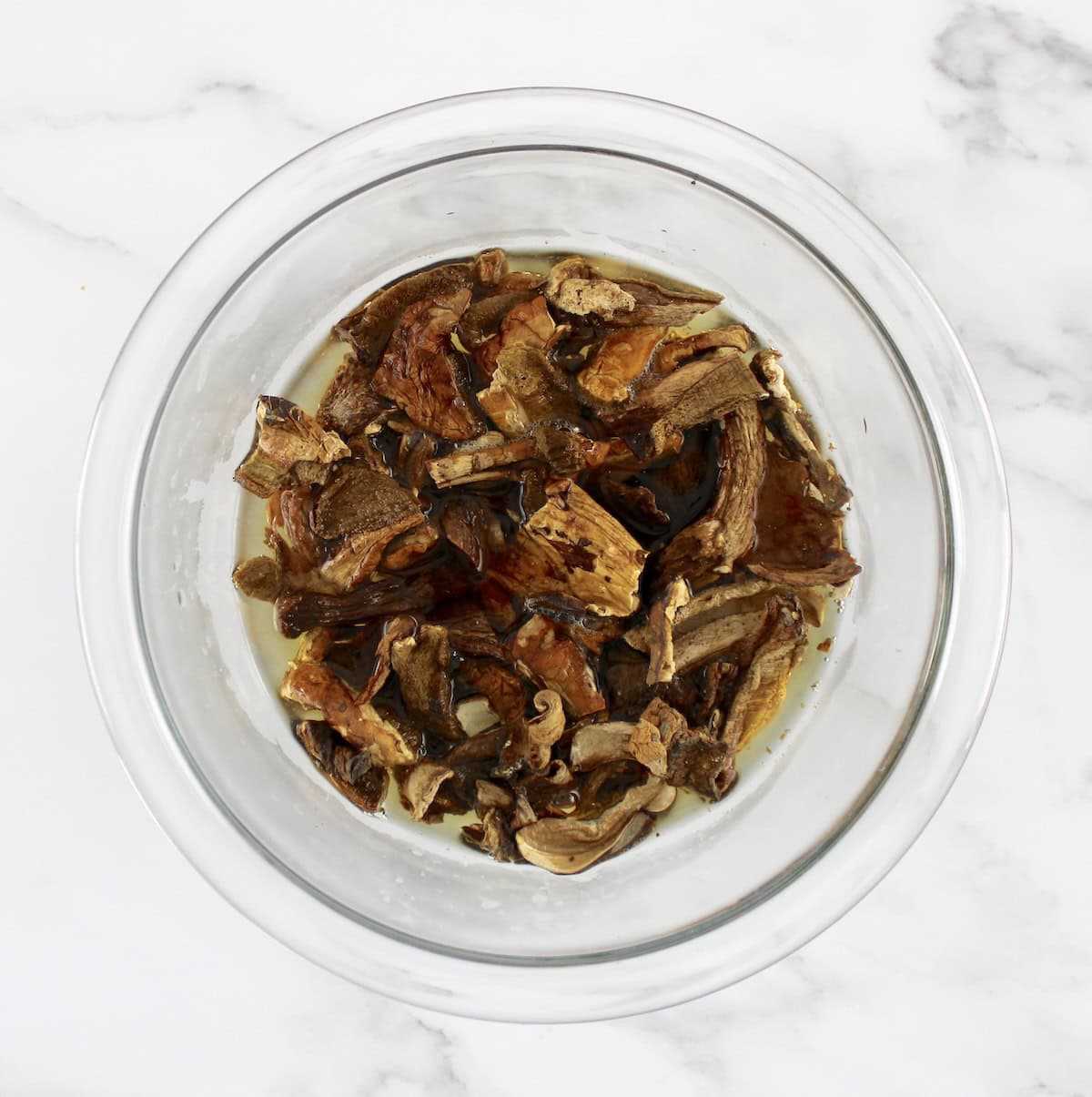 dried porcini mushrooms in glass bowl with water