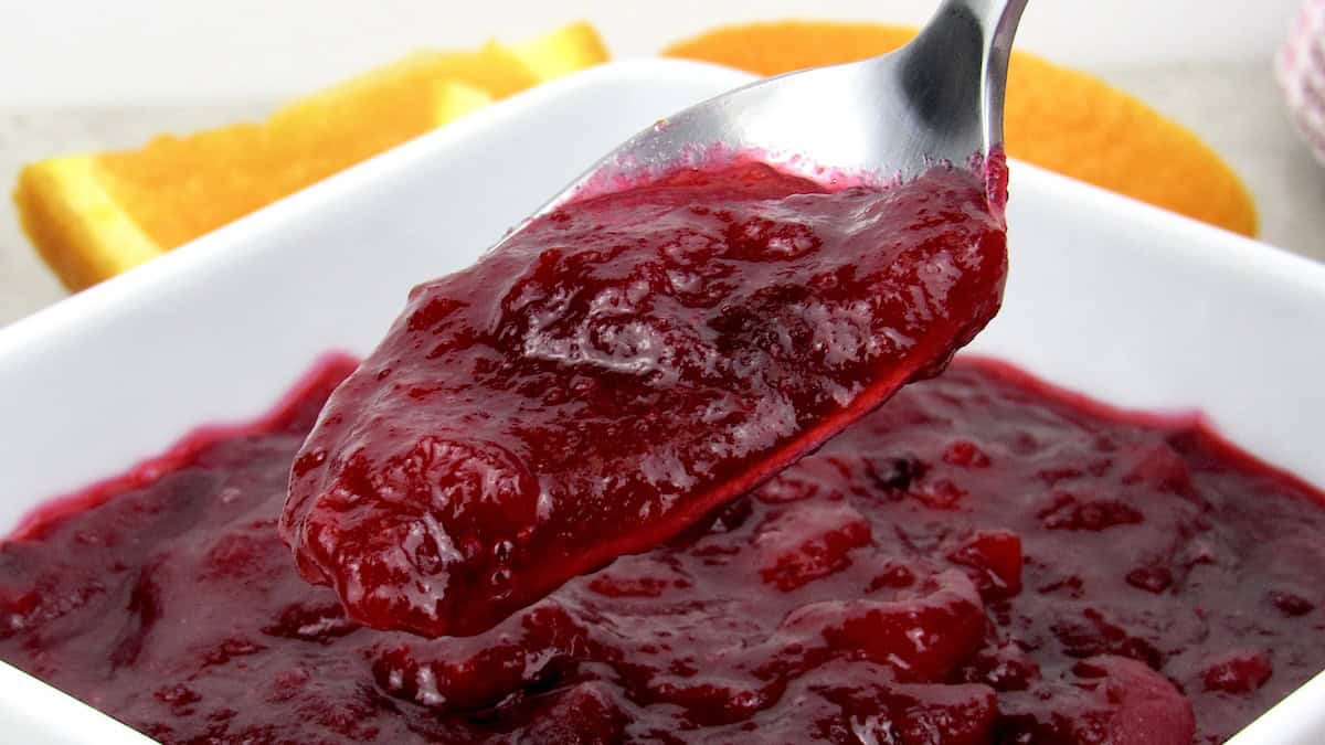 cranberry sauce in white bowl with spoonful