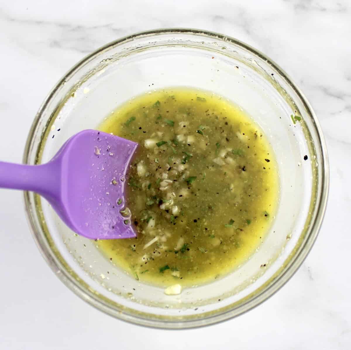 Roast Beef garlic butter rub in glass bowl with purple spoon