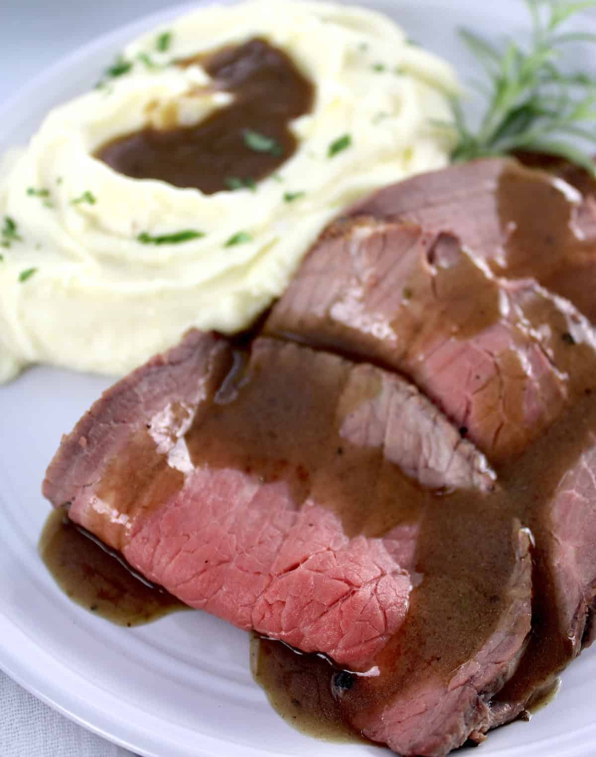 Roast Beef with Gravy on plate with mashed cauliflower and gravy 