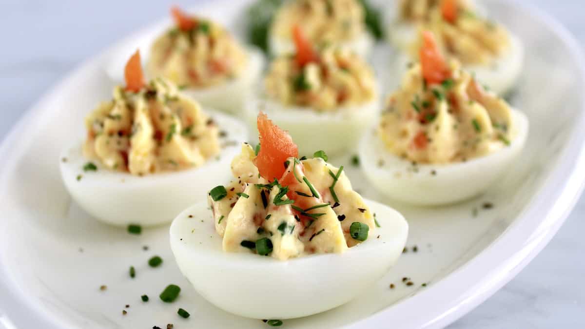 closeup of Smoked Salmon Deviled Eggs on white plate with chopped chives