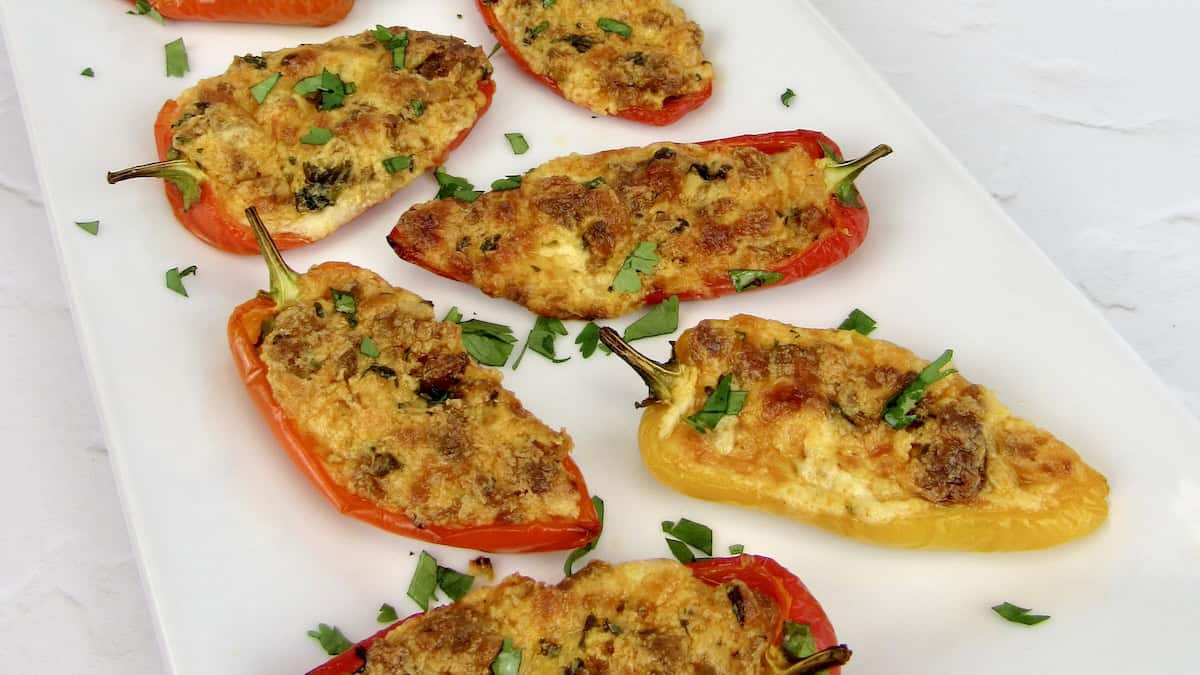 closeup of chorizo and cheese stuffed mini peppers on white plate