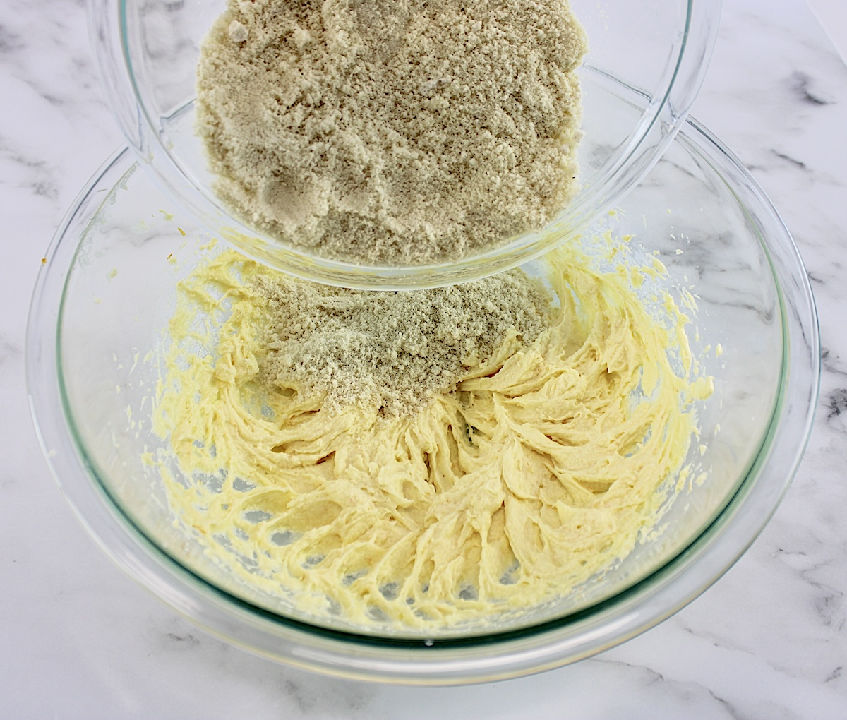 dry ingredients being poured into the wet for Cranberry Thumbprint Cookies