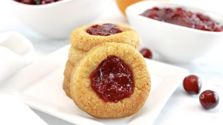 Cranberry Thumbprint Cookies stacked up with one in front and cranberries in back