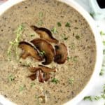 Cream of Wild Mushroom Soup in white bowl with sauteed mushrooms on top