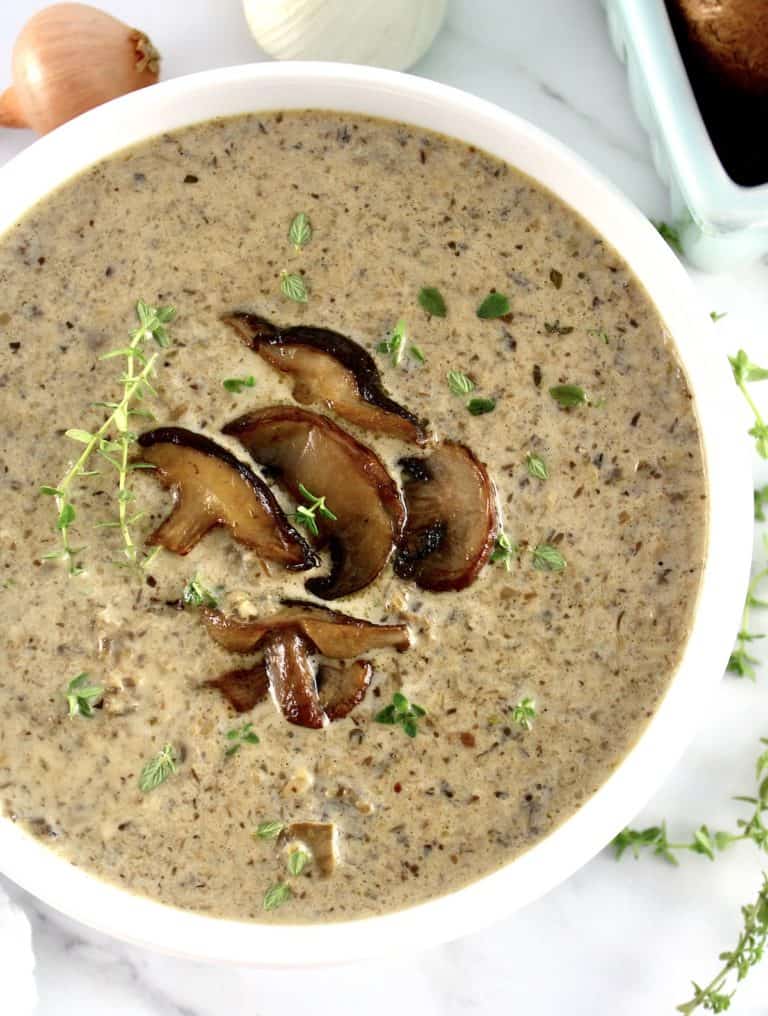 Cream of Wild Mushroom Soup in white bowl with sauteed mushrooms on top