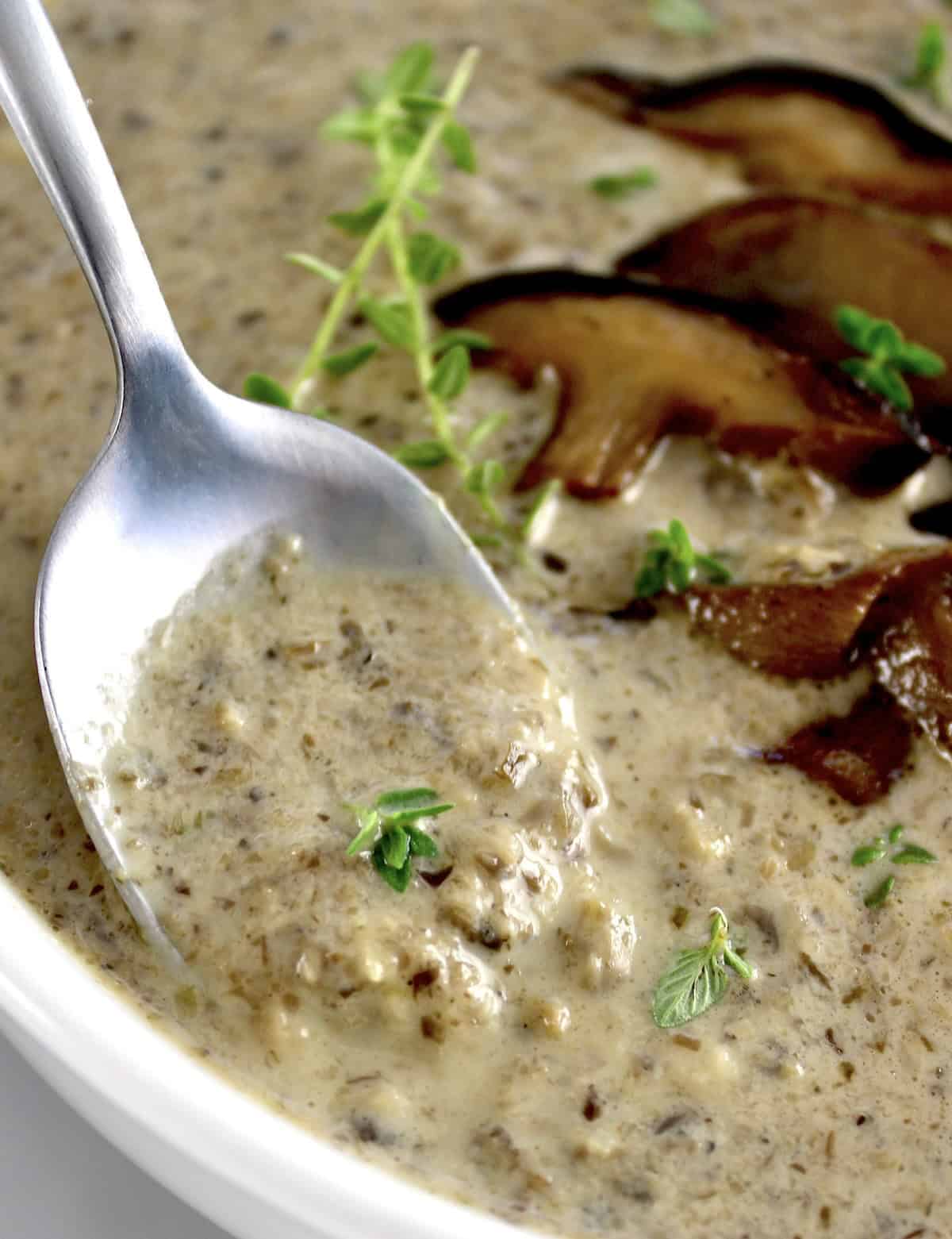 Cream of Wild Mushroom Soup with spoon closeup