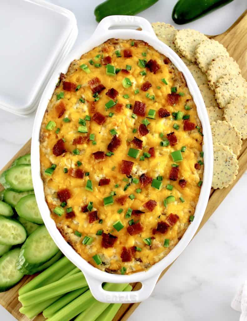 overhead view of Jalapeño Popper Chicken Dip with crackers and veggies around the sides