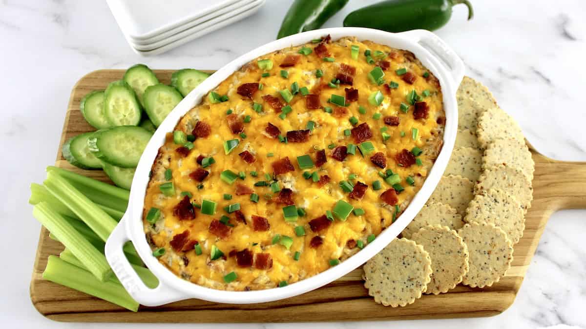 overhead view of Jalapeño Popper Chicken Dip with crackers and veggies around the sides