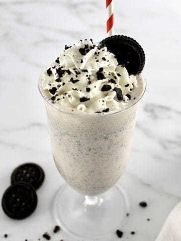 Keto Cookies and Cream Milkshake with oreo on top with whip cream and cookie crumbs