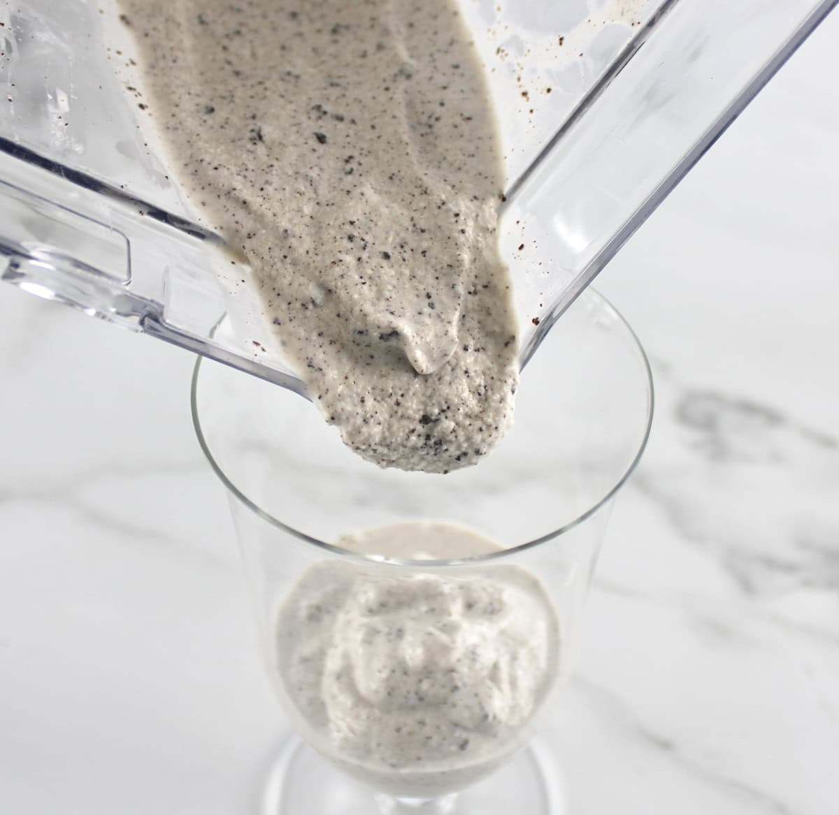 Keto Cookies and Cream Milkshake being poured from blender into glass