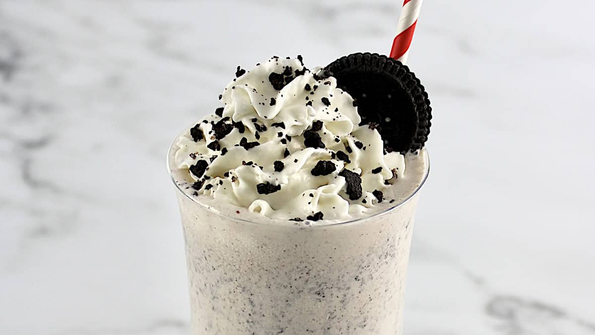 Keto Cookies and Cream Milkshake in glass with whip  cream and crumbled cookies on top