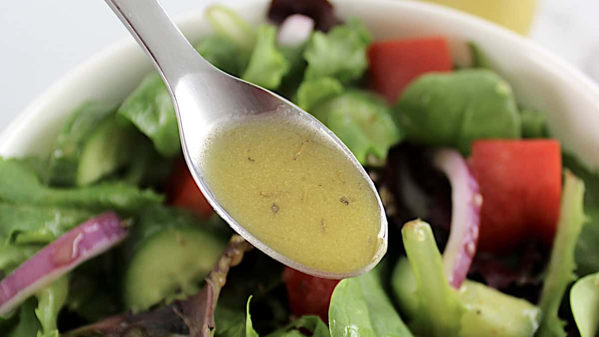 Maple Dijon Vinaigrette being spooned over salad